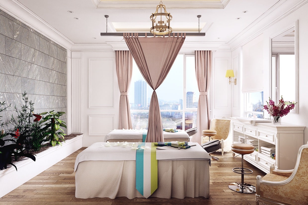 Bright spa room with massage tables, pink curtains, gold chandelier, wood flooring, and city view through windows